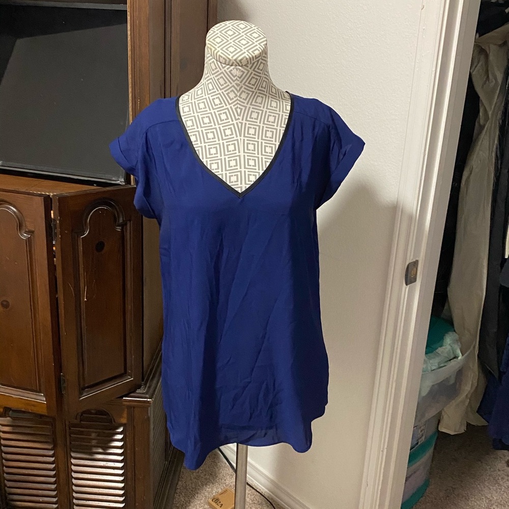 Blue blouse with black trim on the neck